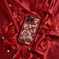 Phone case with red and white design on a red fabric background with bows