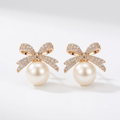 Pearl bow rhinestone stud earrings on white studio background — SugarShell